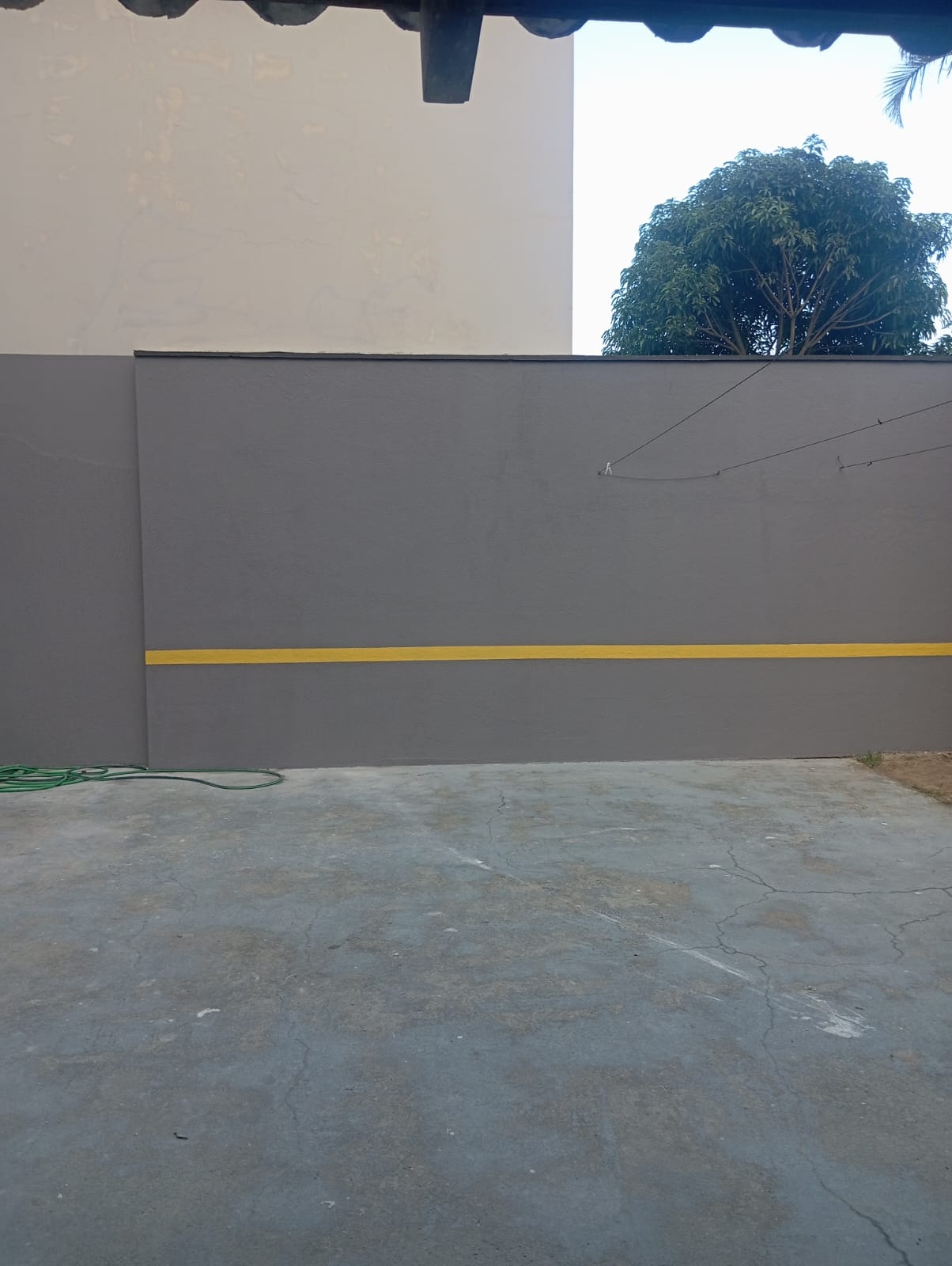 Muro com pintura cinza e detalhe amarelo